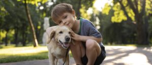 Niño abrazando a un perro en el parque
